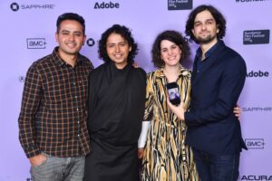 Agent of Happiness- Four creators in front of sponsor board